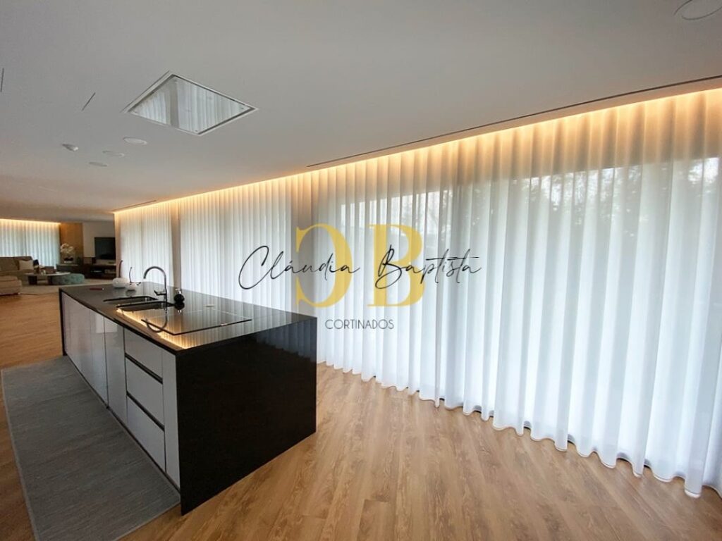 Cozinha aberta com cortinados de ondas em voile branco e luz indireta no teto