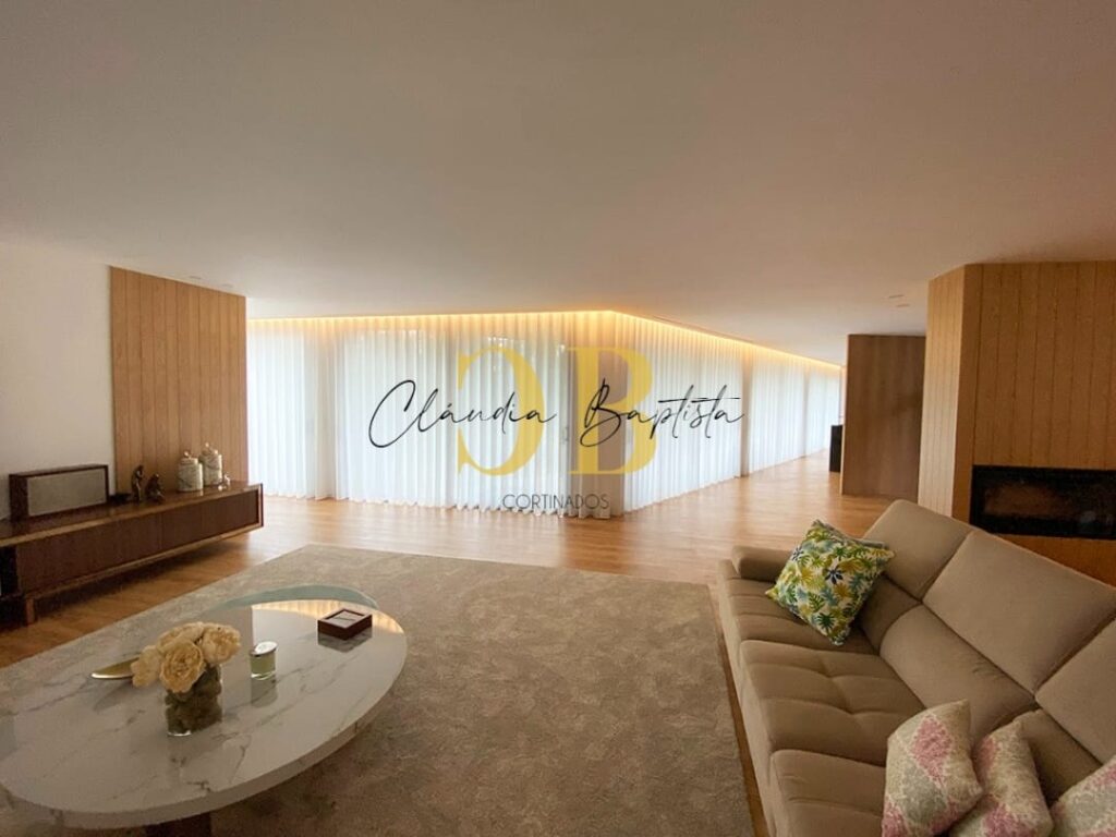 Sala ampla com cortinados de ondas brancos ao longo das janelas